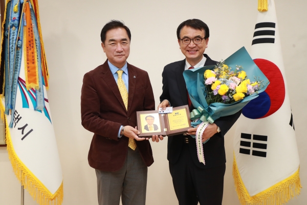 정장선 평택시장(왼쪽)이 김인국 평택 SOFA국민지원센터장에게 명예시민패를 건네고 있다.(사진=평택시)