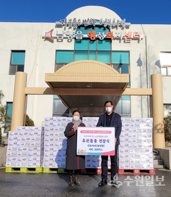 양웅철 진로식재마트 남양점 대표(오른쪽)가 김문수 남양읍장에게 라면 300상자를 기탁한 뒤 기념촬영을 하고 있다.
