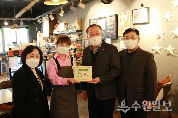 이범선 장안구청장(오른쪽 두번째)이 김옥진 일디즈 카페 대표에게 인증 현판을 건네고 있다.(사진=장안구)
