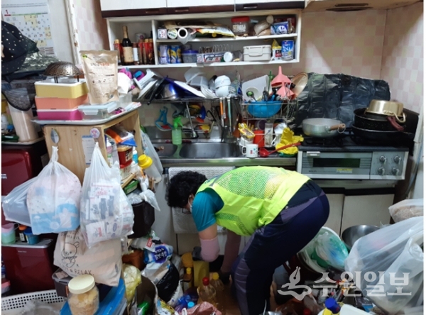독거가정 실내에 쌓여있는 쓰레기를 봉사요원이 치우고 있다.