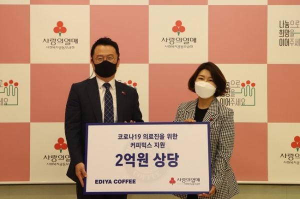 커피전달식에서  이디야커피 목정훈 경영관리본부장(왼쪽)과 사랑의열매 김경희 사회공헌본부장이 기념촬영을 하고 있다.(사진=사랑의 열매)