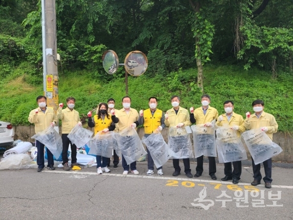 18일 이범선 장안구청장(왼쪽에서 5번째)을 비롯한 간부공무원과 주민들이 연무동 일대에서 공용 재활용봉투를 이용해 생활폐기물 분리작업을 벌인 뒤 기념촬영을 하고 있다. (사진=장안구)