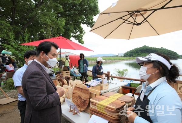 백군기 용인시장이 처인구 원삼면 용담호수에서 열린  '제2회 용담호수뚝마켓' 에서 관계자들과 이야기를 나누고 있다.(사진=용인시)