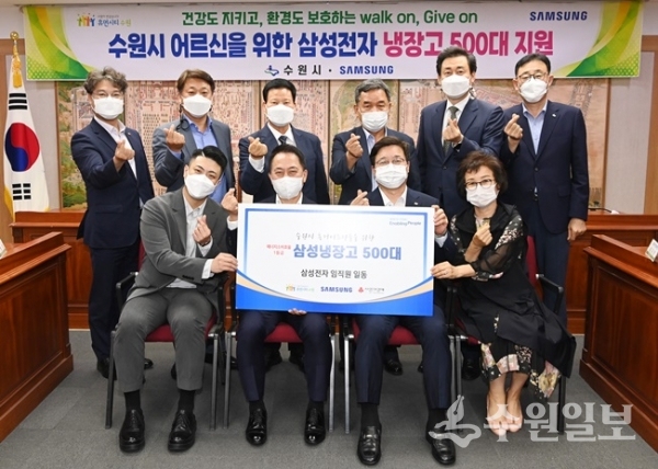 염태영 시장(앞줄 오른쪽 2번째), 최윤호 삼성전자 사장(앞줄 왼쪽 2번째), 동 지역사회보장협의체 구별 대표위원장, 수원시·삼성전자 관계자가 전달식 후 기념촬영을 하고 있다. (사진=수원시)