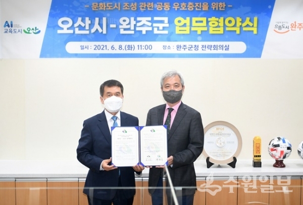 곽상욱 오산시장(왼쭉)과 박성일 완주군수가 샹생협약을 체결한뒤 기념촬영 하고 있다.(사진=오산시)