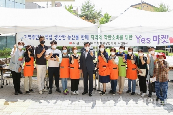 의왕시 지역사회보장협의체가 운영하는 ‘YES마켓’ 현장을 방문한 김상돈 의왕시장(왼쪽에서 7번째)이 협의체 회원들과 기념촬영을 하고 있다. (사진=의왕시)