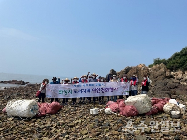 화성 도리도에서 ‘깨끗한 경기 바다 만들기’캠페인에 참여한 참가자들이 정화활동을 벌인 뒤 기념촬영을 하고 있다. (사진=화성시)