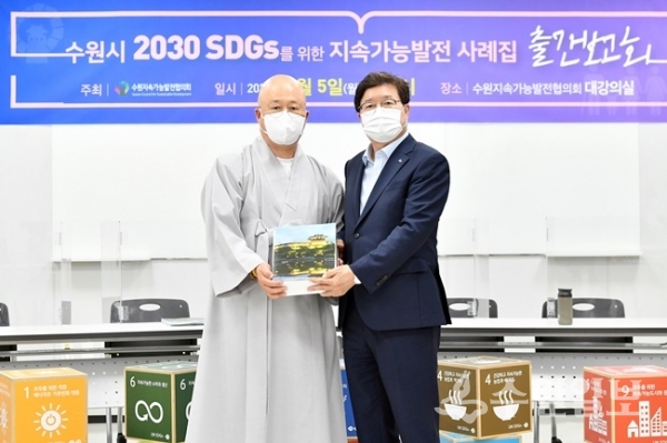 ‘지속가능발전 사례집 출간보고회’에서 염태영 수원시장이 수원지속가능발전협의회 공동회장인 수산스님으로부터 책자를 전달받고 있다. (사진=수원시)