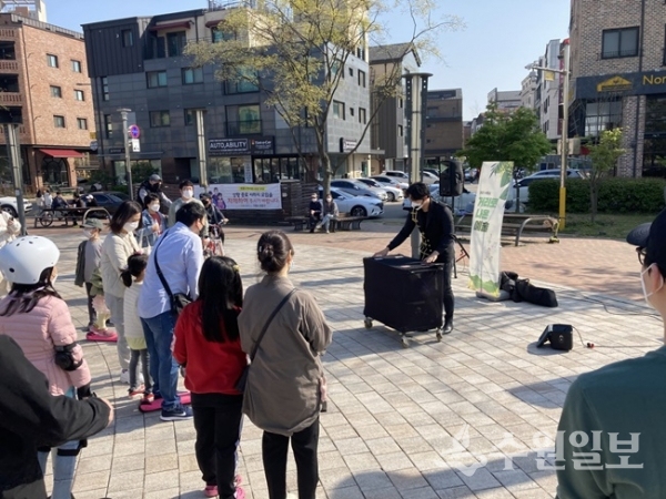 시민들이 ‘거리로 나온 예술’ 프로그램으로 신동카페거리 일원에서 진행된 마술공연 버스킹을 지켜보고 있다. (사진=수원시)