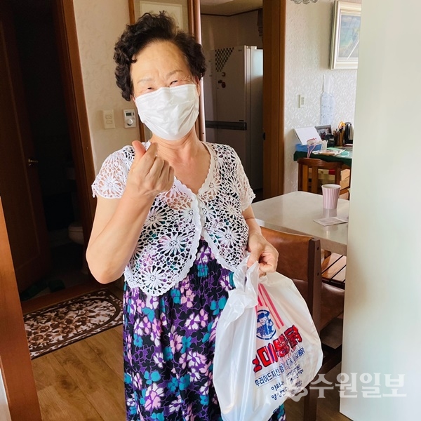 ​​​​​​​수원지역 한 돌봄노인이 지역 내 민간 자원으로 연계된 건강식품을 전달받은 뒤 활짝 웃어보이고 있다. (사진=수원시)