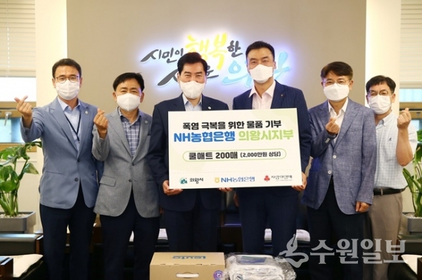 김상돈 의왕시장이 한명호 NH농협은행 의왕시지부장으로부터 여름철 폭염극복을 위한 쿨매트를 전달받은 뒤 양 기관 관계자들과 기념촬영을 하고 있다. (사진=의왕시)