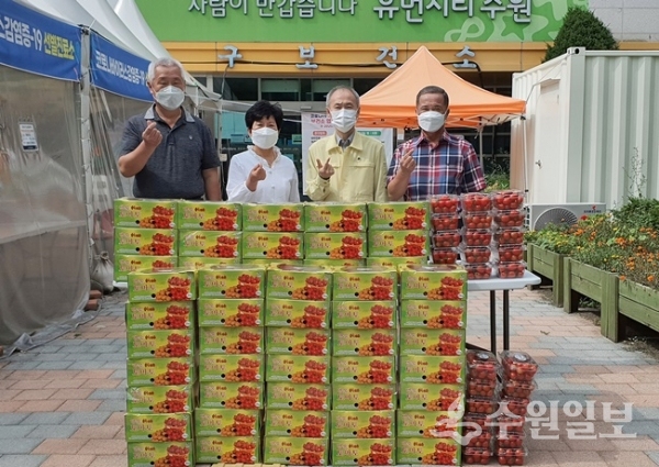 박희원 한국농촌지도자수원시연합회장(오른쪽 첫번째)이 권용찬 수원시 장안구보건소장(오른쪽 두번째)에게 방울토마토를 전달한 뒤 농업인단체 관계자들과 함께 기념촬영을 하고 있다. (사진=수원시)