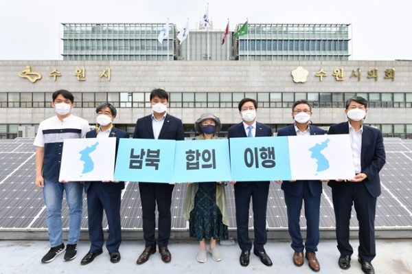 염태영 수원시장(오른쪽에서 3번째), 유문종 수원시 제2부시장, 조석환 수원시의회 의장 등이 ‘남북합의이행’이라고 적힌 카드섹션을 하며 기념촬영하고 있다.(사진=수원시)