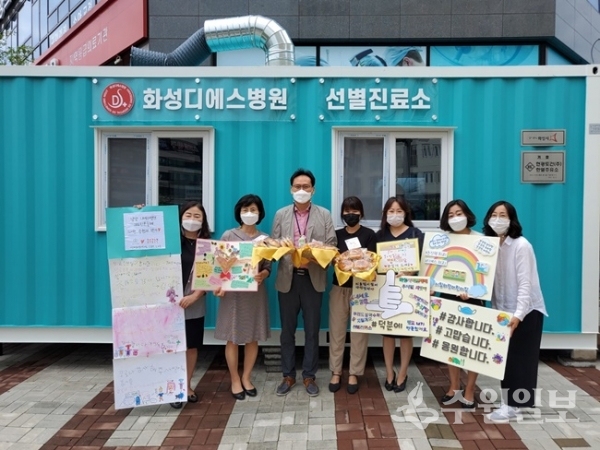 6개어린이집 어린이 300여명이 화성밀로 직접만든 빵과 쿠키를  화성디에스 병원에 마련된 코로나 선별진료소에 전달하고 관계자들이 기념촬영 하고 있다.(사진=화성시)