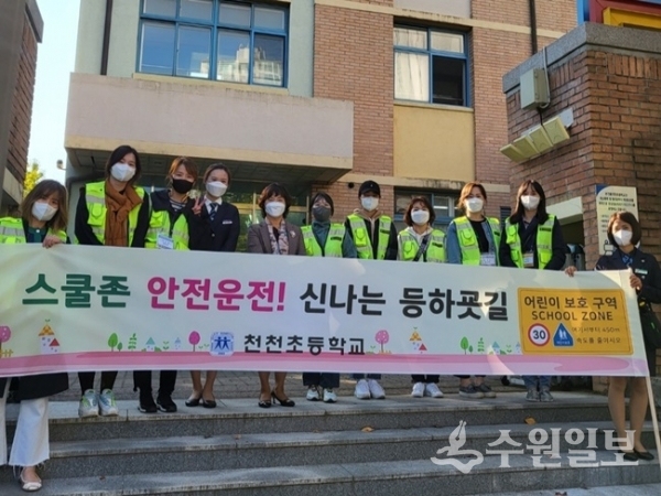 천천초등학교 학부모회원들이 학교주변 공사현장 횡단보도에서 안전운전 캠페인을 벌이고 있다.