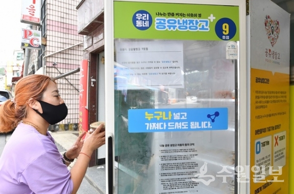 지역별 먹거리 나눔을 위해 설치된 공유냉장고를 관리하고 있는 자원봉사자.(사진=수원시)