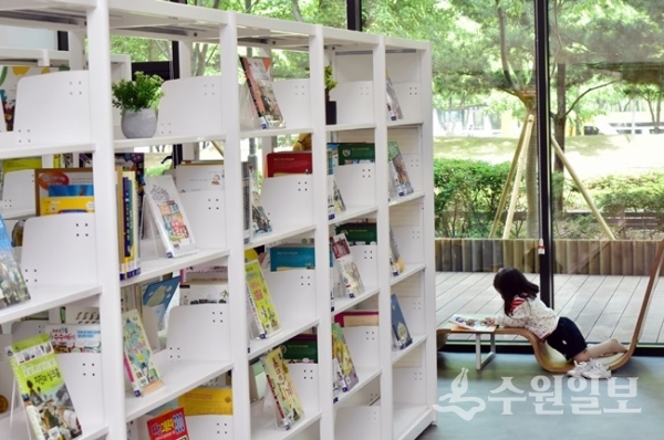 '여기가 도서관 맞습니까?' 그림책을 특화주제로 운영되는 매여울도서관 책뜰에서 한 어린이가 책을 보고 있다.(사진=수원시)
