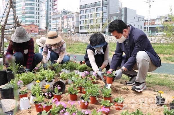 백군기(오른쪽) 시장이 시민들과 함께 어울림 정원에서 꽃을 심고 있다.(사진=용인시)