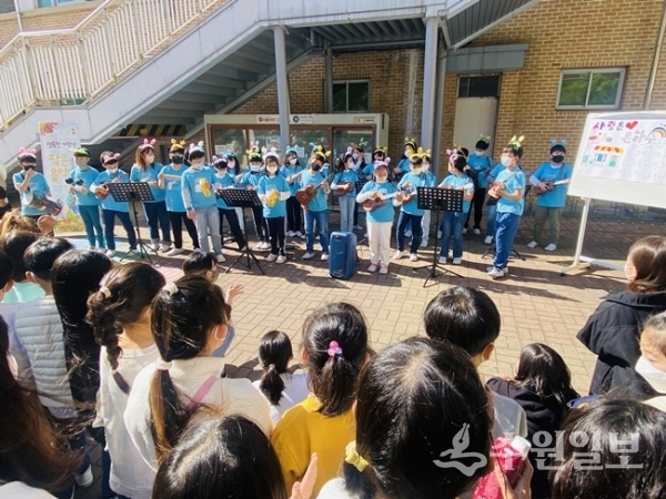 아침 등굣길에 4학년생들이 우쿨렐레를 연주하며 작은음악회를 갖고 있다.