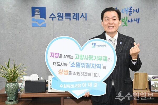 이재준 수원시장이 기부 후 대도시와 ‘소멸위험 지역’의 상생을 실천하겠다는 내용의 손팻말을 들고 있다. (사진=수원시)