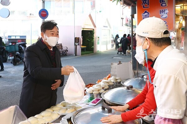 김성제 의왕시장(왼쪽)이 20일 부곡도깨비시장에서 장보기를 하면서 지역상인들과 대화를 나누고 있다. (사진=의왕시)