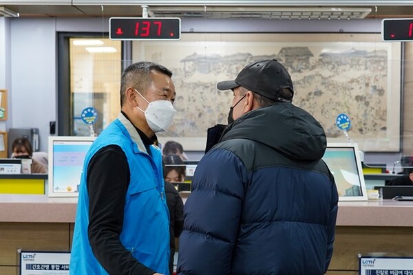 파란 조끼를 입은 이춘택병원 직원이 환자에게 동행안내 서비스를 하고 있다.(사진=이춘택병원)