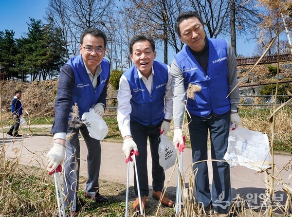 이재준 수원시장(가운데), 김경진 삼성전자 부사장(왼쪽) 등이 원천리천에서 쓰레기를 줍고 있다. (사진=수원시)