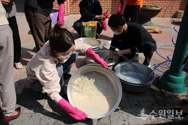 수원시자원봉사센터 관계자와 수원지역 자원봉사단체 관계자들이 ‘사랑의 밥차’ 운영을 앞두고 시험 가동을 위해 쌀을 씻고 있다. (사진=수원시)