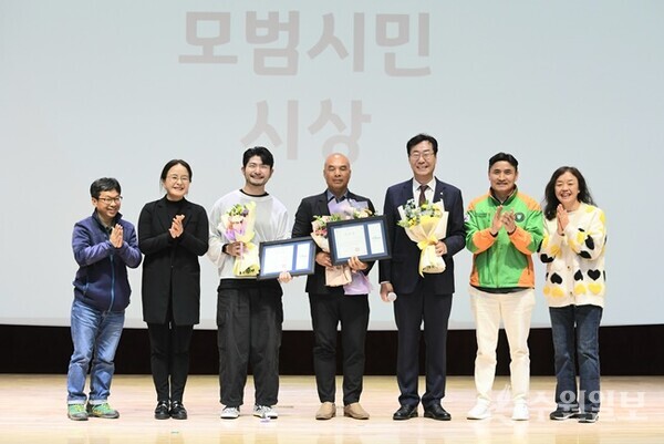 정명근 화성시장(오른쪽에서 세번쨰)이 타인을 위해 목숨을 걸고 봉사한 의인 2명에게 ‘모범 시민상’을 시상한 뒤 관계자들과 함께 기념촬영을 하고 있다. (사진=화성시)