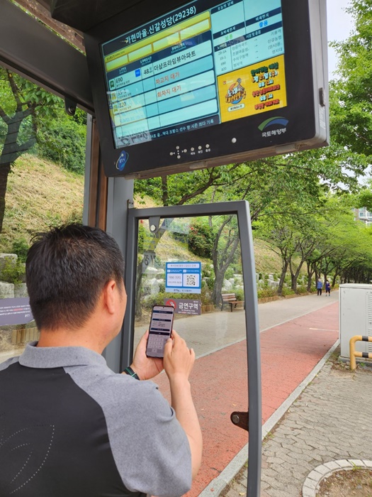 용인시가 버스안내전광판 고장 때 QR코드로 쉽게 신고할 수 있는 서비스를 시작한다. 시민이 QR코드를 인식하는 모습.(사진=용인시)