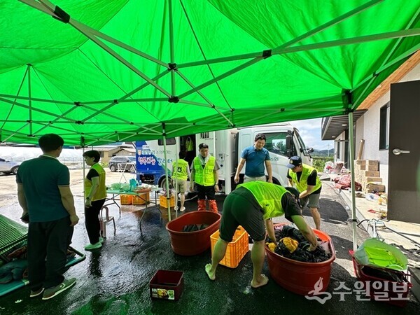 화성 태안농협 직원들이 수재지역 생활복 세탁을 위해 구슬땀을 흘리고 있다. (사진=태안농협)
