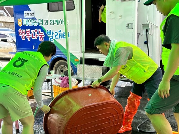김형규 태안농협 조합장(가운데)이 직원들과 함께 세탁봉사를 하고 있다. (사진=태안농협)