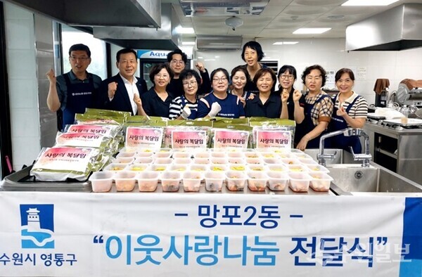 수원시 망포2동 지역사회보장협의체 회원들이 관내 저소득 홀몸어르신들에게 전달할 사랑의 복달임 꾸러미 앞에서 사진촬영을 하고 있다. (사진=영통구)