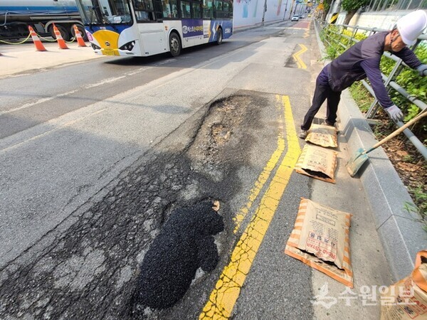 도로 위에 발생한 포트홀을 ‘포트홀 24시 기동대응반’ 관계자가 보수를 하고 있다. (사진=수원시)