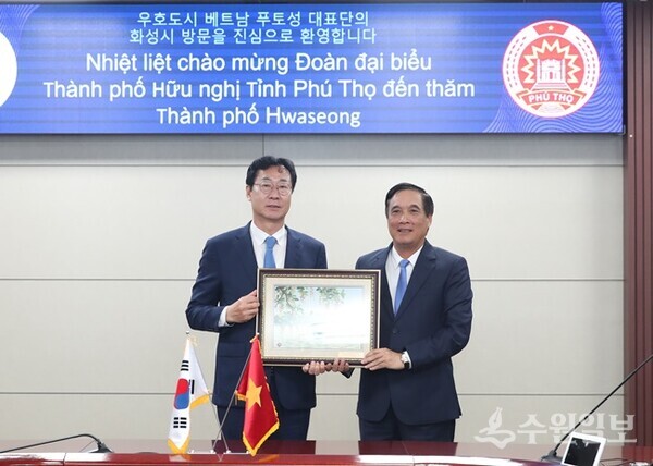 정명근 화성시장(왼쪽) 부이 민 짜우(Bui Minh Chau) 베트남 푸토성 당서기와 악수를 하고 있다. (사진=화성시)