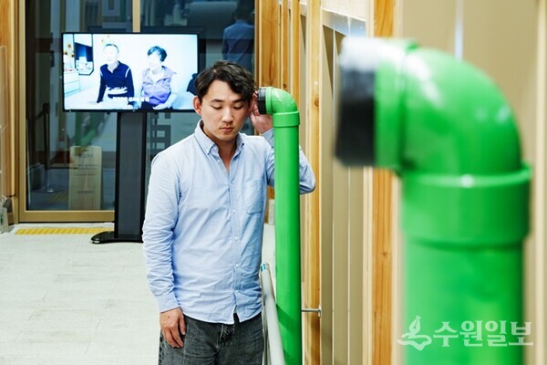 한 시민이 미디어홀(수원시미디어센터) 1층에 전시된 미디어아트 작품의 소리를 듣고 있다.(사진=수원시)