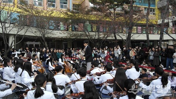 학생들이  등굣길에 S-오케스트라단의 연주를 경청하고 있다. (사진=신풍초교)