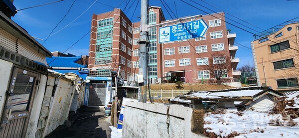 대문이 보이는 집이 정재진와 박진순씨가 63년 동안 살고 있는 집. 뒷쪽은 삼일공고, 오른쪽은 폐가가 자리잡고 있다. (사진=김충영 기자)