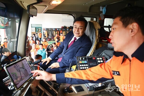 김성제 의왕시장(왼쪽)이 긴급차량에 직접 탑승해 의왕소방서 관계자로부터 우선신호시스템에 대한 설명을 듣고 있다. (사진=의왕시)