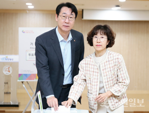 정명근 화성시장이 부인 이선희 여사와 함께 화산동 사전투표소에서 투표함에 투표용지를 넣으면서 포즈를 취하고 있다. (사진=화성시)