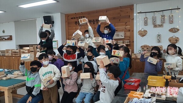 바라산자연휴양림 목공체험장에서 어린이들이 직접 본인이 제작한 목공품을 들어보이고 있다. (사진=의왕시)