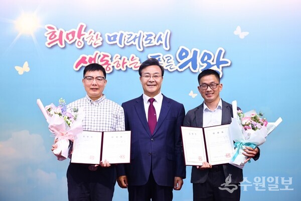 김성제 의왕시장(가운데)이 중국 호북성 셴닝시 교환공무원인 칸시 국유자산관리 위원회 과장(왼쪽)과 저우샤오산 비상관리국 판공실 주임에게 임명장을 전달한 뒤 함께 하고 있다. (사진=의왕시)