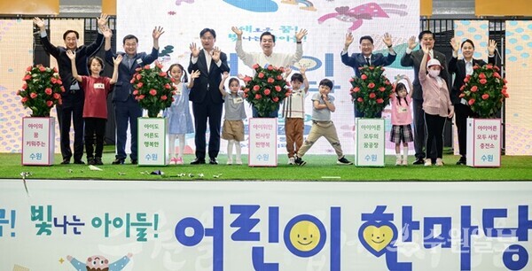 이재준 시장(가운데)과 어린이들, 참석자들이 마술 나무에 물을 뿌린 후 활짝 웃고 있다. (사진=수원시)