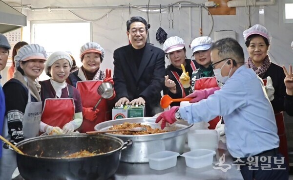김기배 팔달구청장(가운데)이 노후 온수기와 화구 교체작업 지원 후 연무정급식소 봉사자들과 기념촬영을 하고 있다. (사진=이응자 대표)