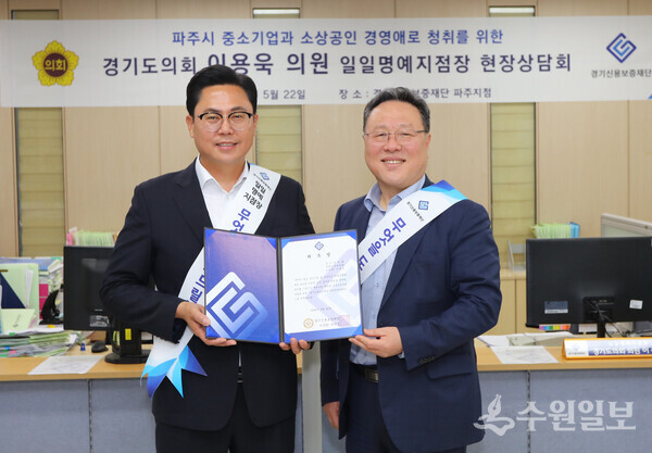이용욱 의원(왼쪽)이 시석중 경기신보 이사장으로부터 1일명예지점장 위촉장을 전달받은 뒤 기념촬영을 하고 있다. (사진=경기신보)