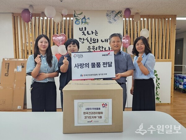 김은수 건협 경기도지부 전략사업부장(오른쪽 두번째)이 김정숙 고운뜰 원장(왼쪽 두번째)에게 후원물품을 전달한 뒤 관계자들과 기념촬영을 하고 있다. (사진=건협 경기도지부)