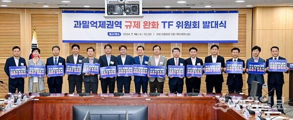 과밀억제권역 규제 완화 TF위원회 대표위원장으로 선출된 이재준 수원시장(오른쪽 8번째부터), 염태영 의원, 이동환 고양시장 등이 TF 위원회 발대식 후 ‘국가경쟁력 회복 과밀억제권역 완화가 답이다’라는 문구가 적힌 손팻말을 들고 기념촬영을 하고 있다. (사진=수원시)
