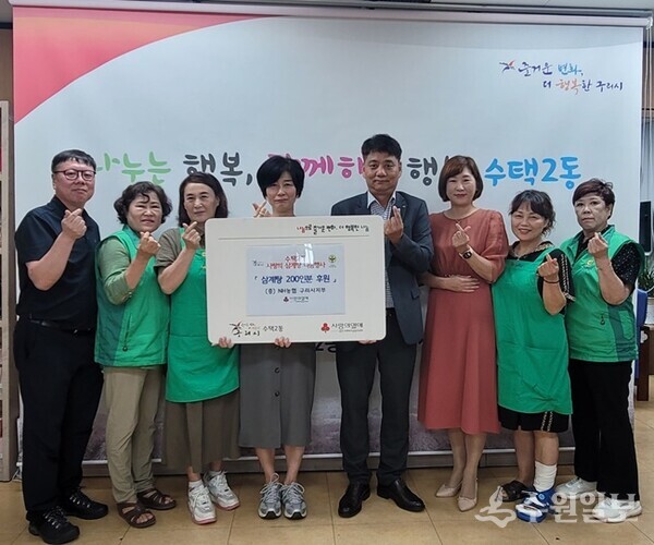 홍준기 NH농협은행 구리시지부장(오른쪽 네번째)이 표영실 구리시 수택2동장에게 삼계탕 200인분을 후원하면서 관계자들과 기념촬영을 하고 있다.(사진 =구리시 수택2동 행정복지센터)