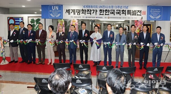 한한국 세계평화작가의 ‘세계평화지도 UN 전시⋅소장 15주년’ 기념 국회특별전 개막식에서 한한국 작가(오른쪽 6번째)가 내빈들과 기념테이프를 자르고 있다. (사진=세계평화사랑연맹)