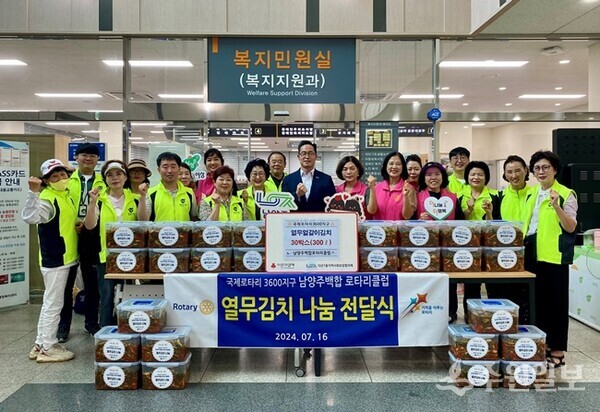 국제로타리3600지구 남양주백합로타리클럽 회원들이 어려운 이웃에 전달해달라며 다산1동 지역사회보장협의체에 열무얼갈이김치 30박스를 기탁하며 관계자들과 기념촬영을 하고 있다. (사진=남양주시)